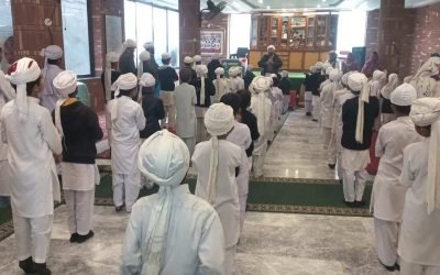 Group of people praying inside a mosque during Quaid-e-Azam Day.