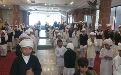 Children praying during Quaid-e-Azam Day at Mohsin Quran Foundation.