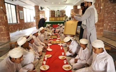 Children and teachers at a Quran learning event in a spacious hall.