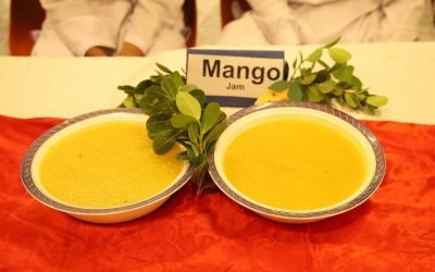 Two bowls of fresh mango jam with greenery and a Mango Jam sign.